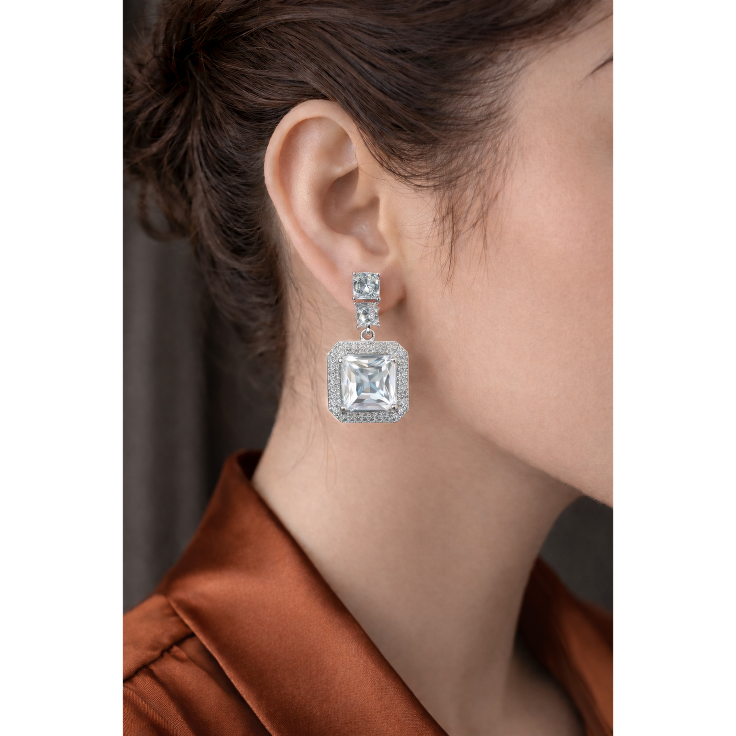 Silver square crystal drop earrings worn by model , contemporary fashion earrings close-up