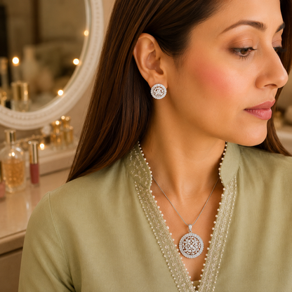 Woman wearing a silver floral crystal pendant necklace and matching stud earrings with a delicate pale pink or crystal clear center stone, photographed in a luxury lifestyle setting