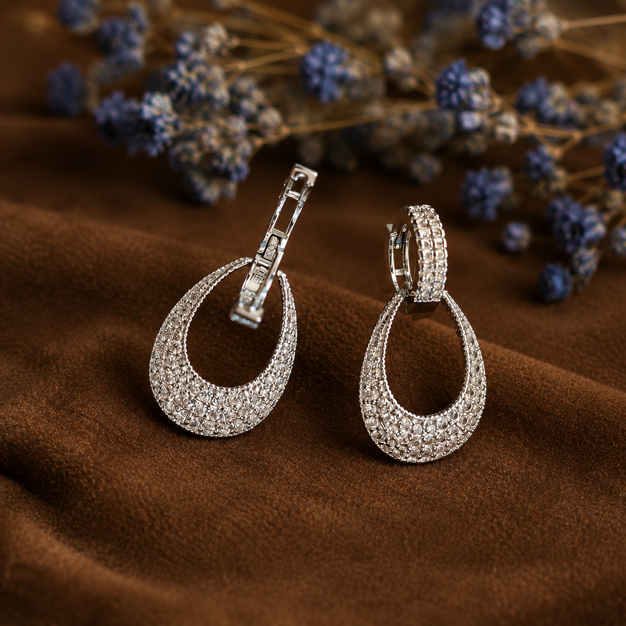 Silver pavé teardrop hoop earrings in open position, showcasing the hinged hoop closure, sparkling crystal detailing, and elegant open drop silhouette.
