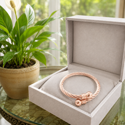 Rose gold overlapping cable cuff bracelet displayed inside a luxury grey velvet jewellery box
