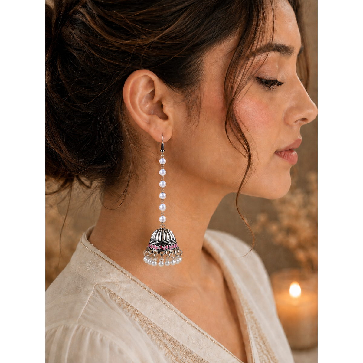 Woman wearing a silver and purple earring with a blurred background