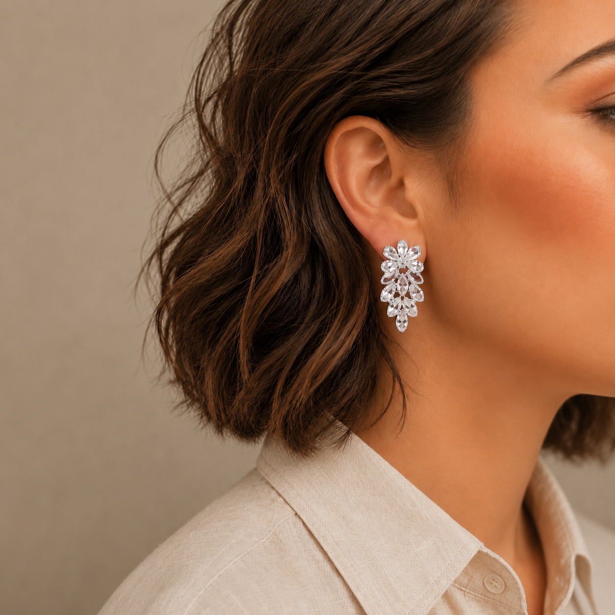 Close-up of a woman wearing a sparkling earring against a neutral background