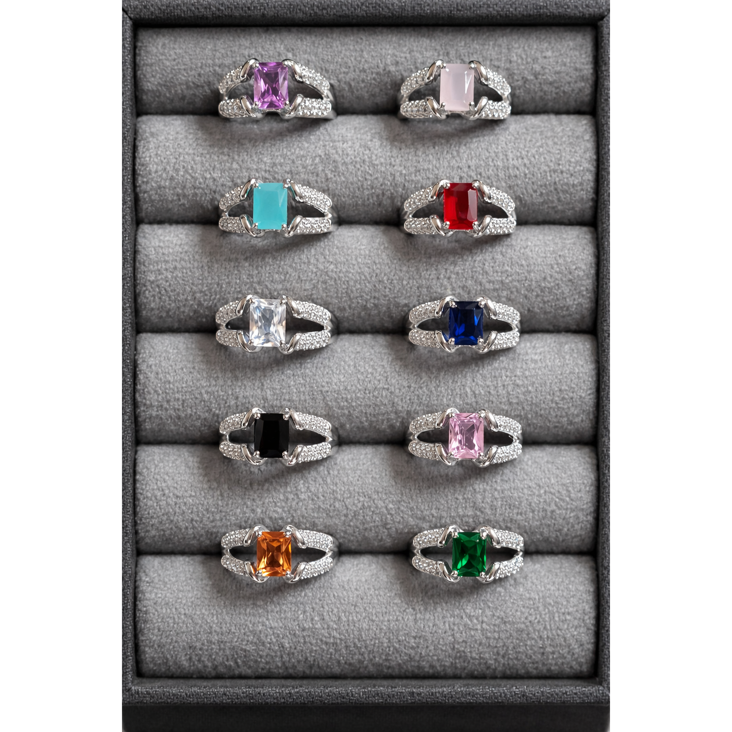 Silver tone adjustable square cut artificial gemstone rings arranged in grey velvet box featuring pink, turquoise, red, blue, green, black and clear stone variants