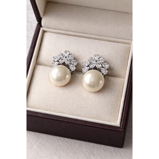 High-definition product photo of floral crystal and ivory pearl earrings displayed inside a premium velvet jewelry box