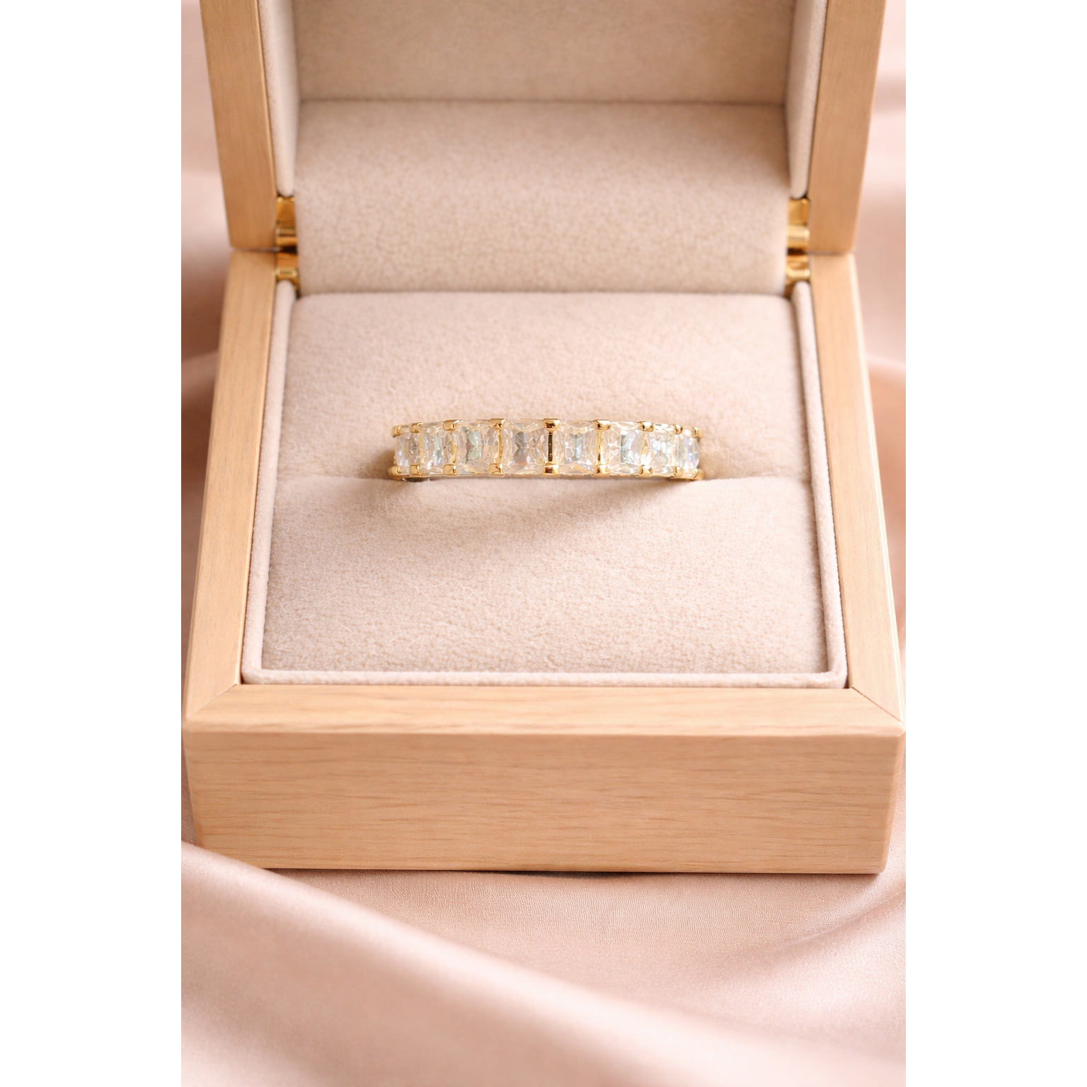 silver ring with crystals in a beige jewelry box on a pink fabric background