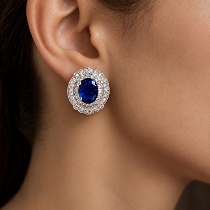 Close-up of Verdanza Oval Stud worn on the ear, featuring an sapphire blue oval centre stone surrounded by intricate clear zircon detailing.