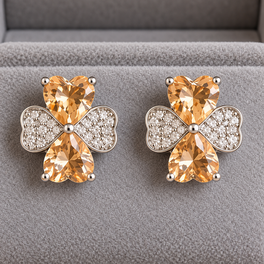  Close up of Silver crystal bow stud earrings featuring champagne heart-cut stones displayed in a premium grey velvet 