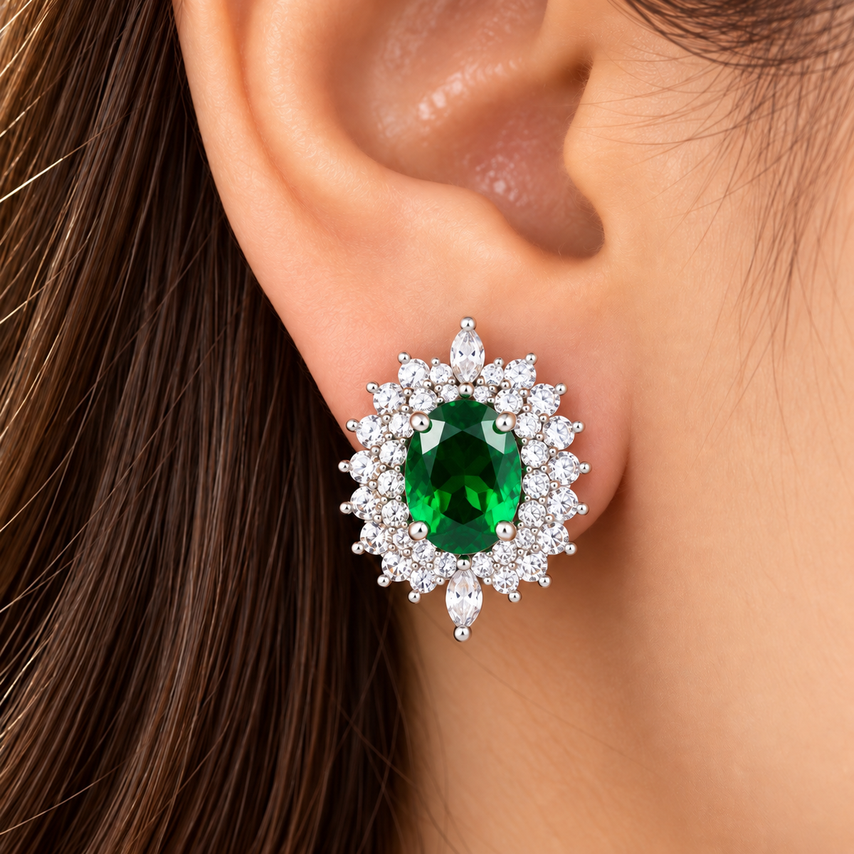 Model wearing The Duchess Oval Studs in emerald green  featuring a large oval centre stone with an ornate clear zircon surround.