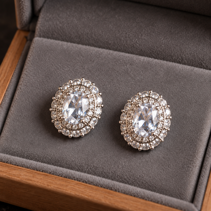 Close-up of silver S925 stud earrings featuring faceted oval  clear centre stones with intricate clear zircon 