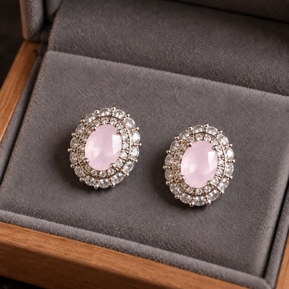 Close-up of silver S925 stud earrings featuring faceted oval pale pink centre stones with intricate clear zircon 