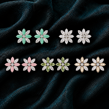 Five Colours: Five pairs of Petal Circuit floral stud earrings in mint green, crystal clear, soft pink, olive green and champagne with marquise-cut stones on dark teal-black fabric