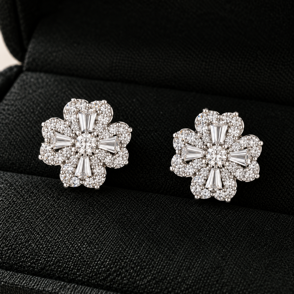 S925 silver Prism Clover Studs displayed in a black jewellery box, featuring four sculpted petals with tapered baguette and clear zircon detailing.