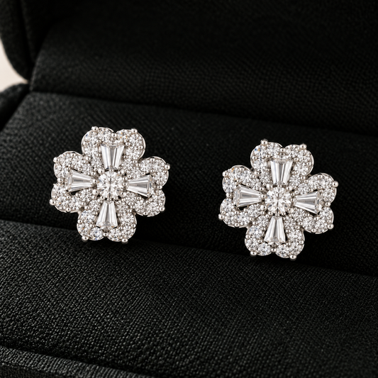 S925 silver Prism Clover Studs displayed in a black jewellery box, featuring four sculpted petals with tapered baguette and clear zircon detailing.
