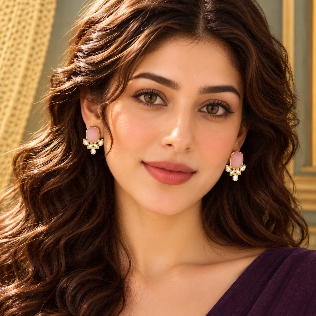 Model wearing Legacy Crownleaf Studs featuring a pink cushion-shaped centre stone with clear leaf-cut accents in a polished gold-tone settin