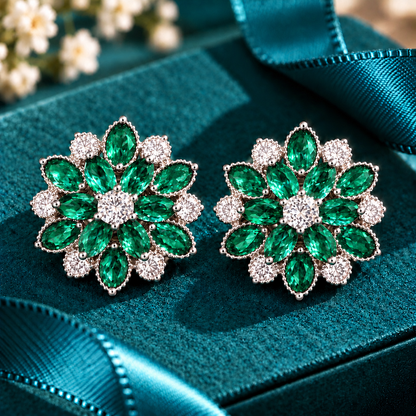 Vespera Bloom Earrings in emerald green, featuring layered marquise-cut gemstones, clear zircon accents and polished silver-tone settings, displayed on a teal jewellery box