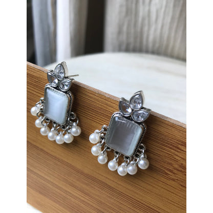 Earrings with gemstones and pearls on a wooden surface