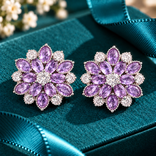 Vespera Bloom Earrings in Amethyst Purple, featuring layered marquise-cut gemstones, clear zircon accents and polished silver-tone settings, displayed on a teal jewellery box