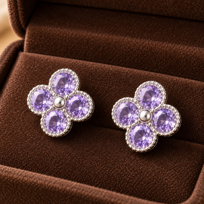 Silver floral stud earrings with lavender crystals in a four-petal clover design displayed in a mocha velvet jewellery