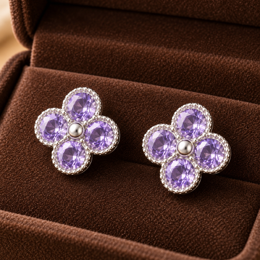 Silver floral stud earrings with lavender crystals in a four-petal clover design displayed in a mocha velvet jewellery