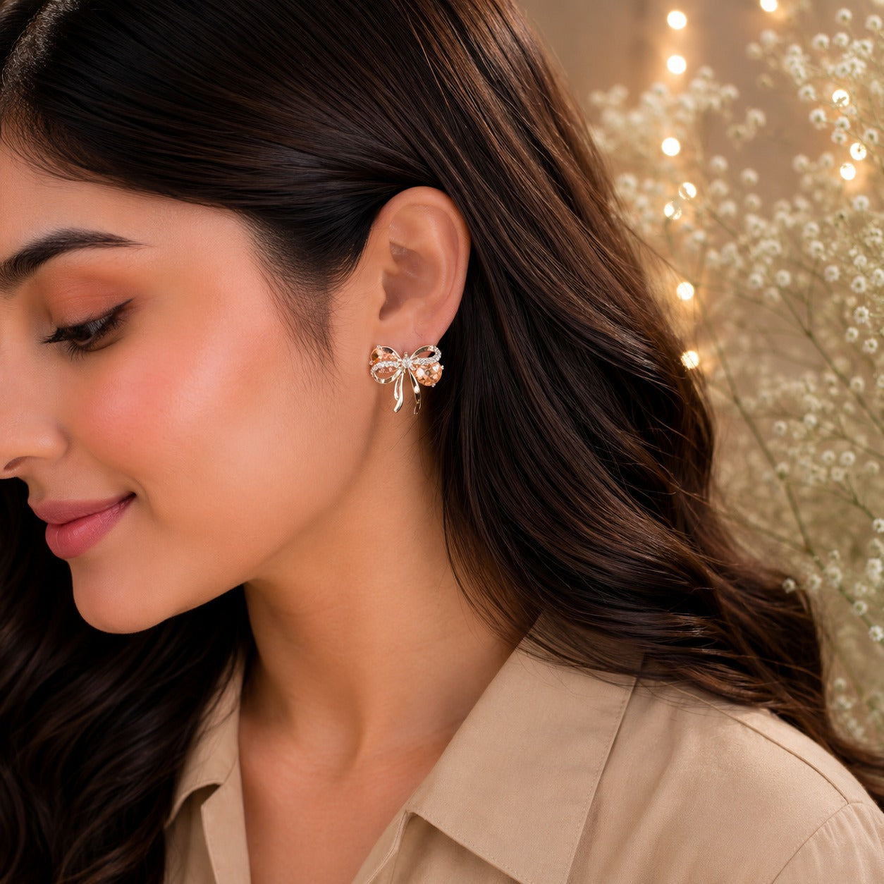 Champagne peach bow stud earrings worn by model with beige satin shirt.