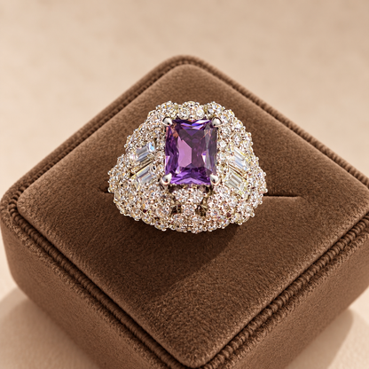 Amethyst Imperial Crest Ring featuring a rectangular purple centre stone surrounded by clear zircon detailing, displayed on a mocha brown velvet jewellery box.