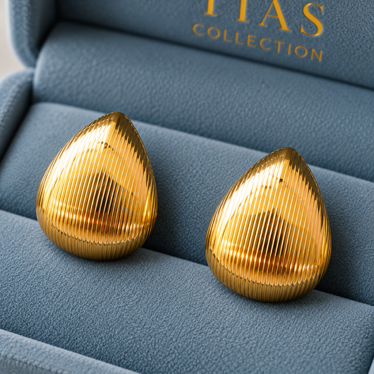  Close up of Gold-tone rounded drop earrings with fine vertical ridged texture and a softly domed finish.
