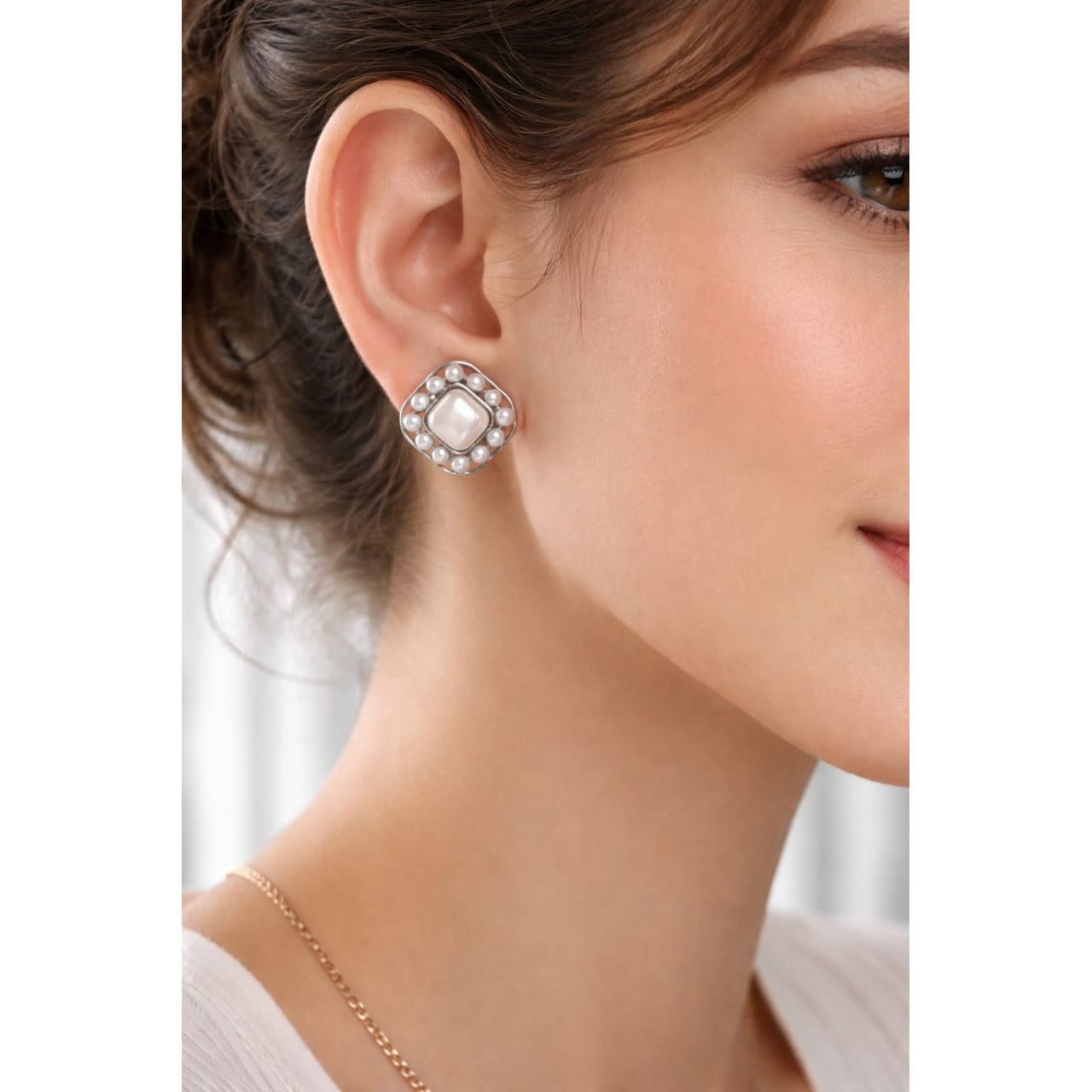 Silver pearl square stud earrings with mother-of-pearl center worn on model ear, realistic size view and natural jewellery styling close-up.