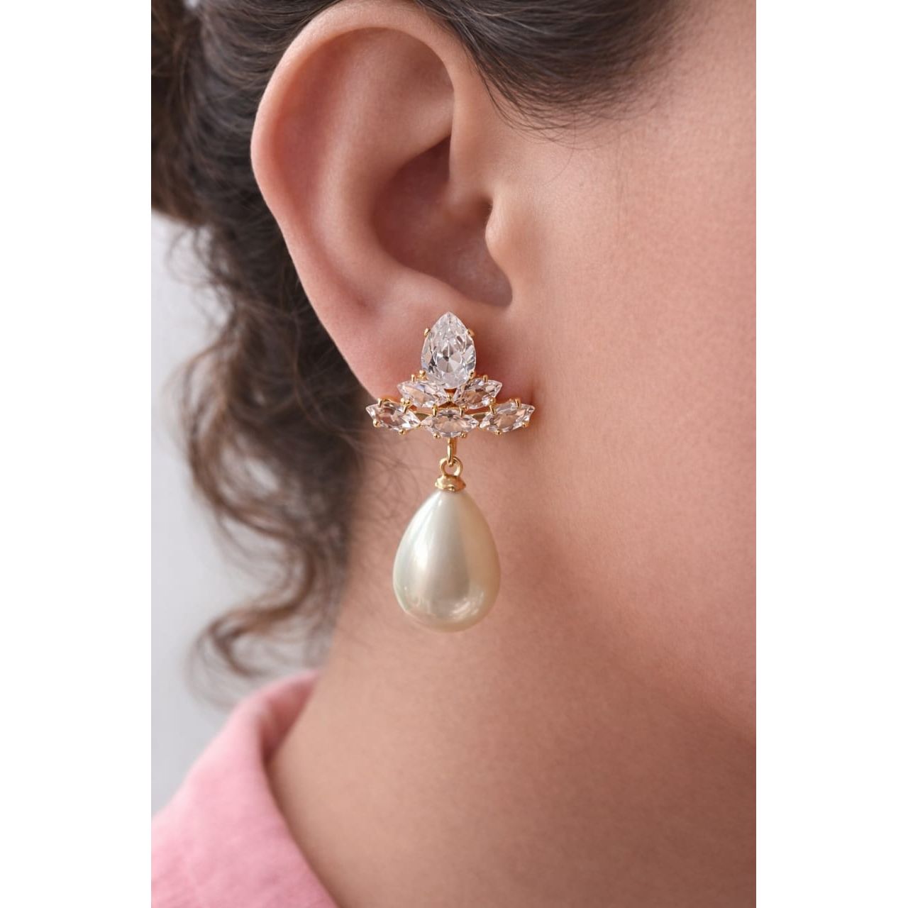 Pearl white teardrop crystal earrings worn on model with gold-tone crystal cluster, high-shine finish