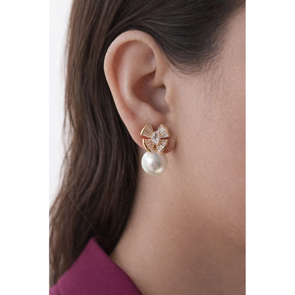 Gold-tone crystal fan earrings with round pearl drop worn on model, close-up ear view