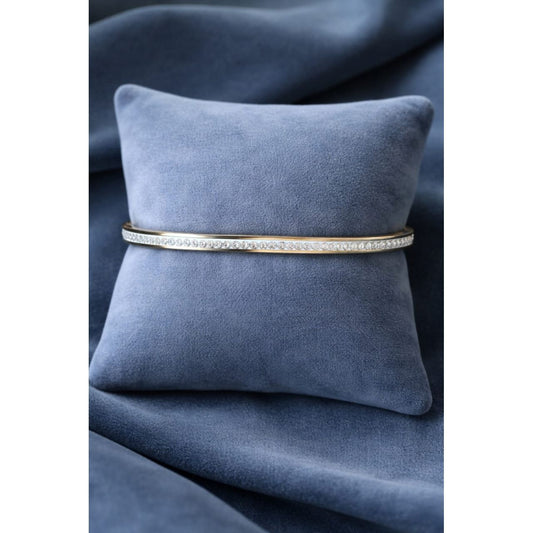 Gold crystal bracelet displayed on blue velvet cushion highlighting slim modern design and fine crystal detailing