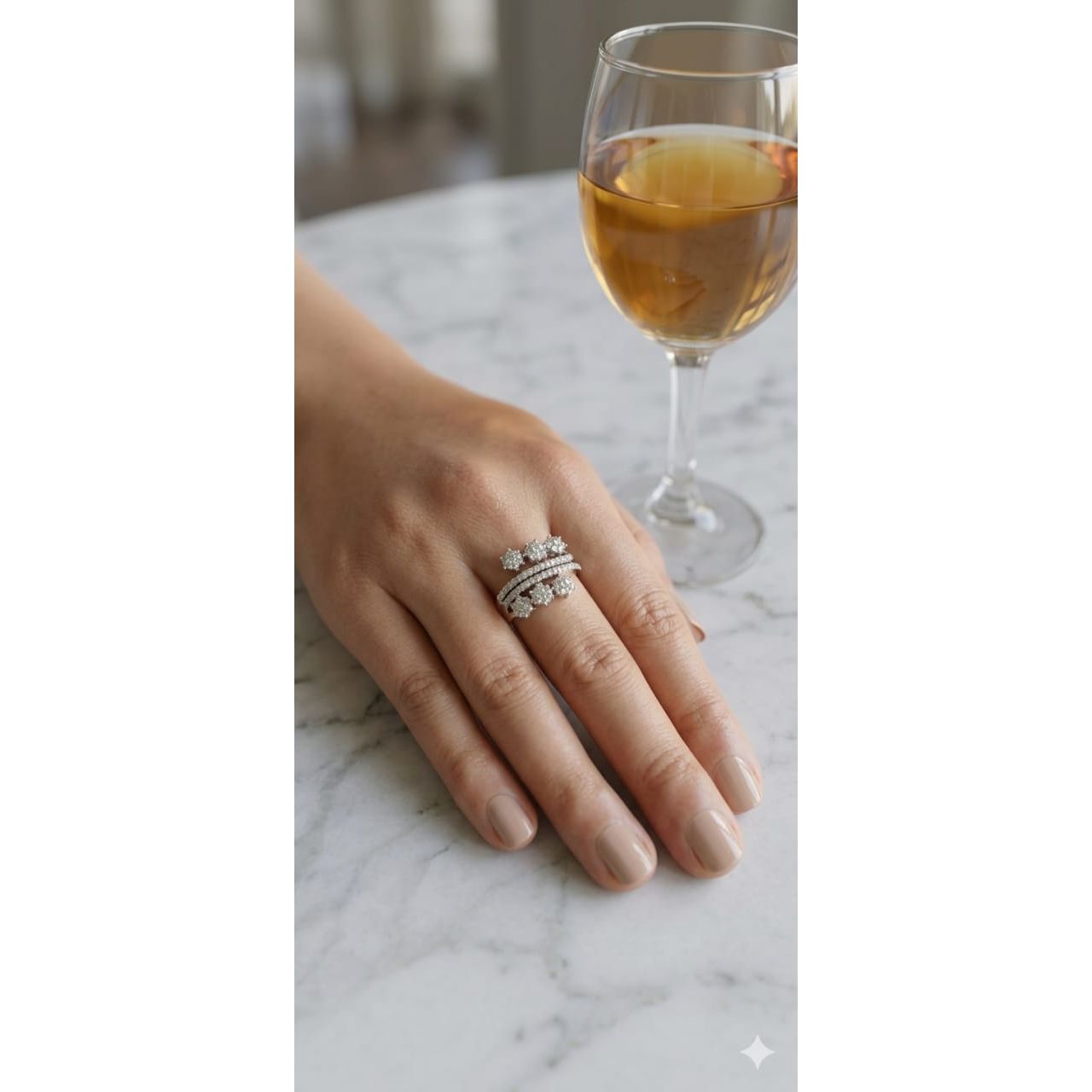 Silver floral cluster statement ring worn on hand with dual pavé bands on marble table setting