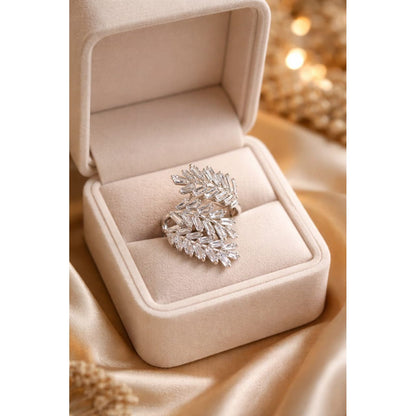 Silver crystal cluster ring displayed inside a beige velvet jewelry box with soft lighting highlighting its baguette stone arrangement