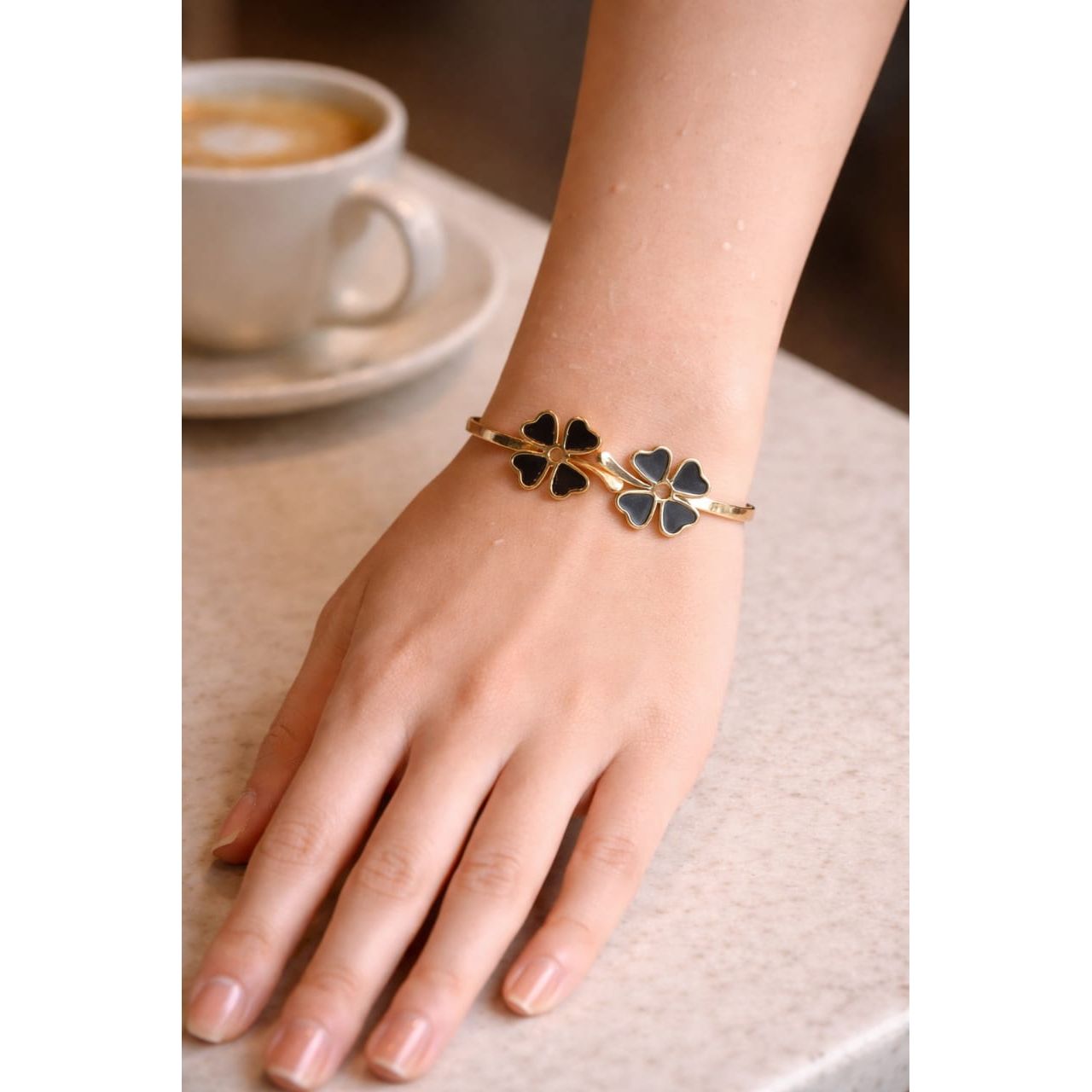 Premium gold tone black clover bracelet with magnetic clasp worn on wrist