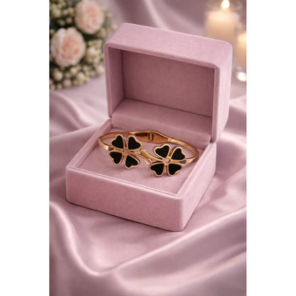 Black clover bracelet with magnetic lock in premium gold tone displayed in pink jewelry