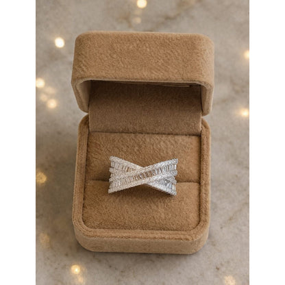 Adjustable silver crisscross baguette zircon ring displayed in a premium beige velvet jewelry box with soft lighting