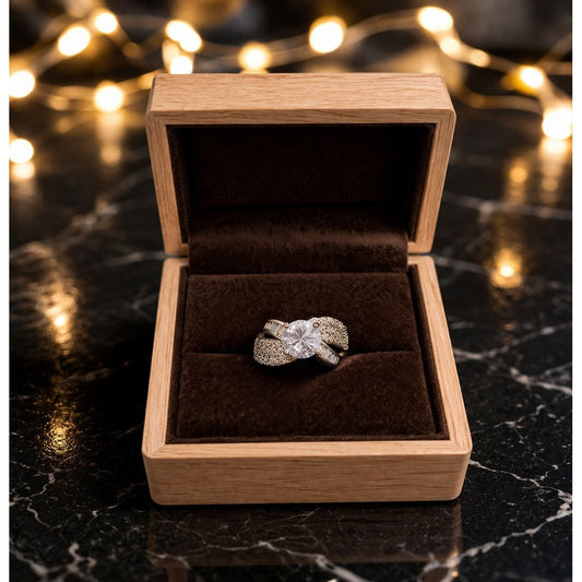 Adjustable silver crystal ring placed inside wooden jewelry box with dark velvet lining and warm fairy lights background