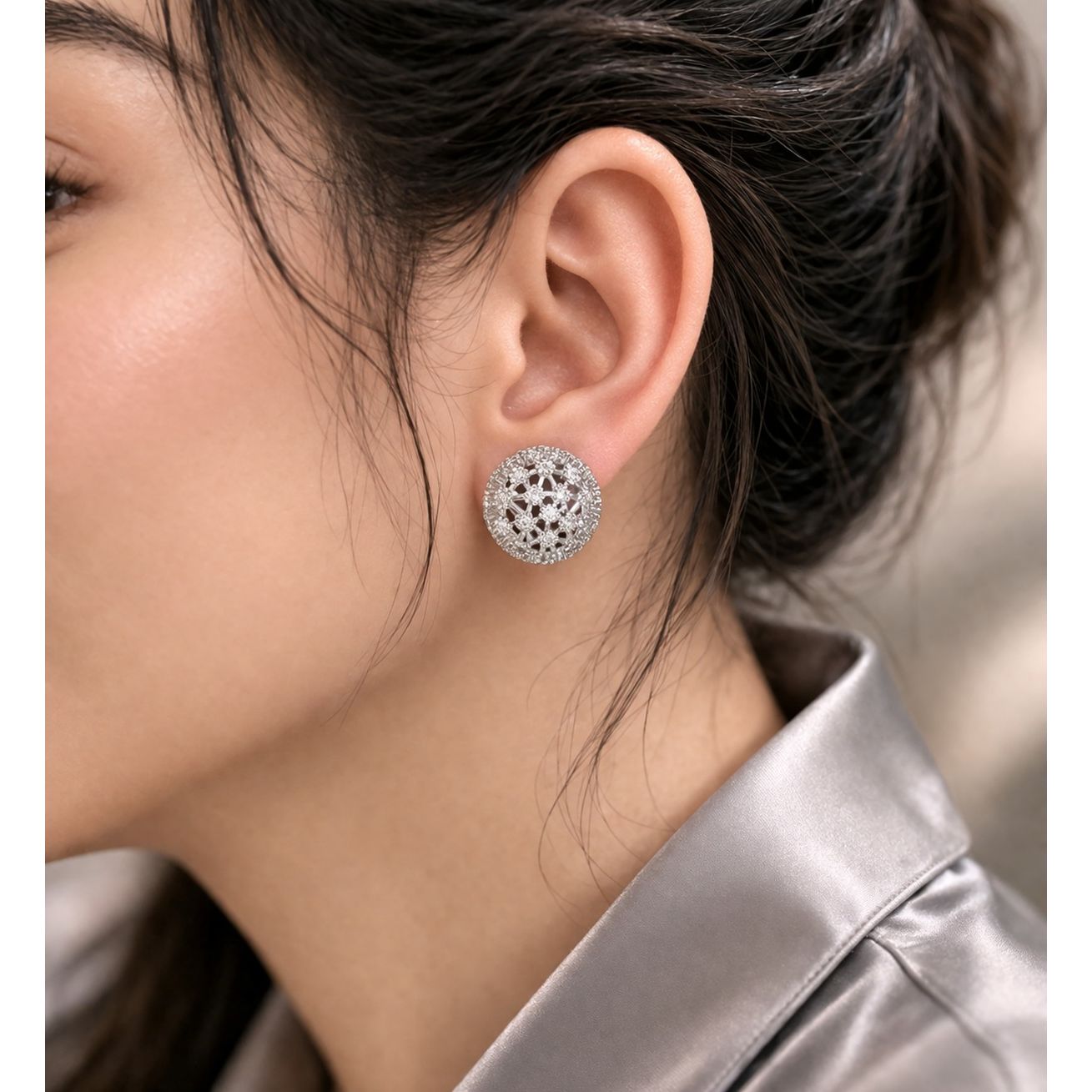 Silver crystal dome earrings worn on ear with soft natural lighting and smooth satin outfit