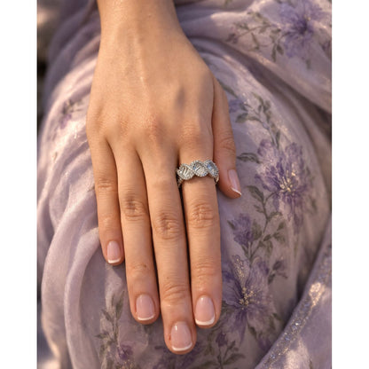 Silver textured open ring worn on hand with soft floral fabric background