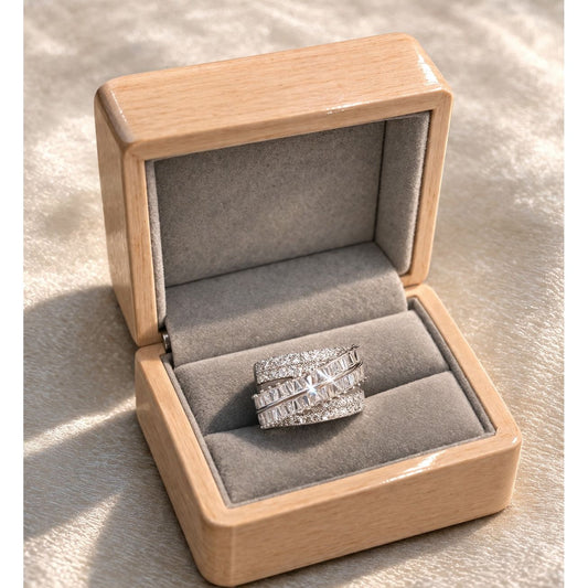 Silver stacked statement ring with baguette stones displayed in wooden velvet jewelry box on satin surface