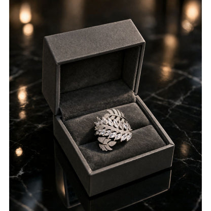 Silver leaf pattern marquise crystal ring displayed in premium dark jewelry box on marble surface