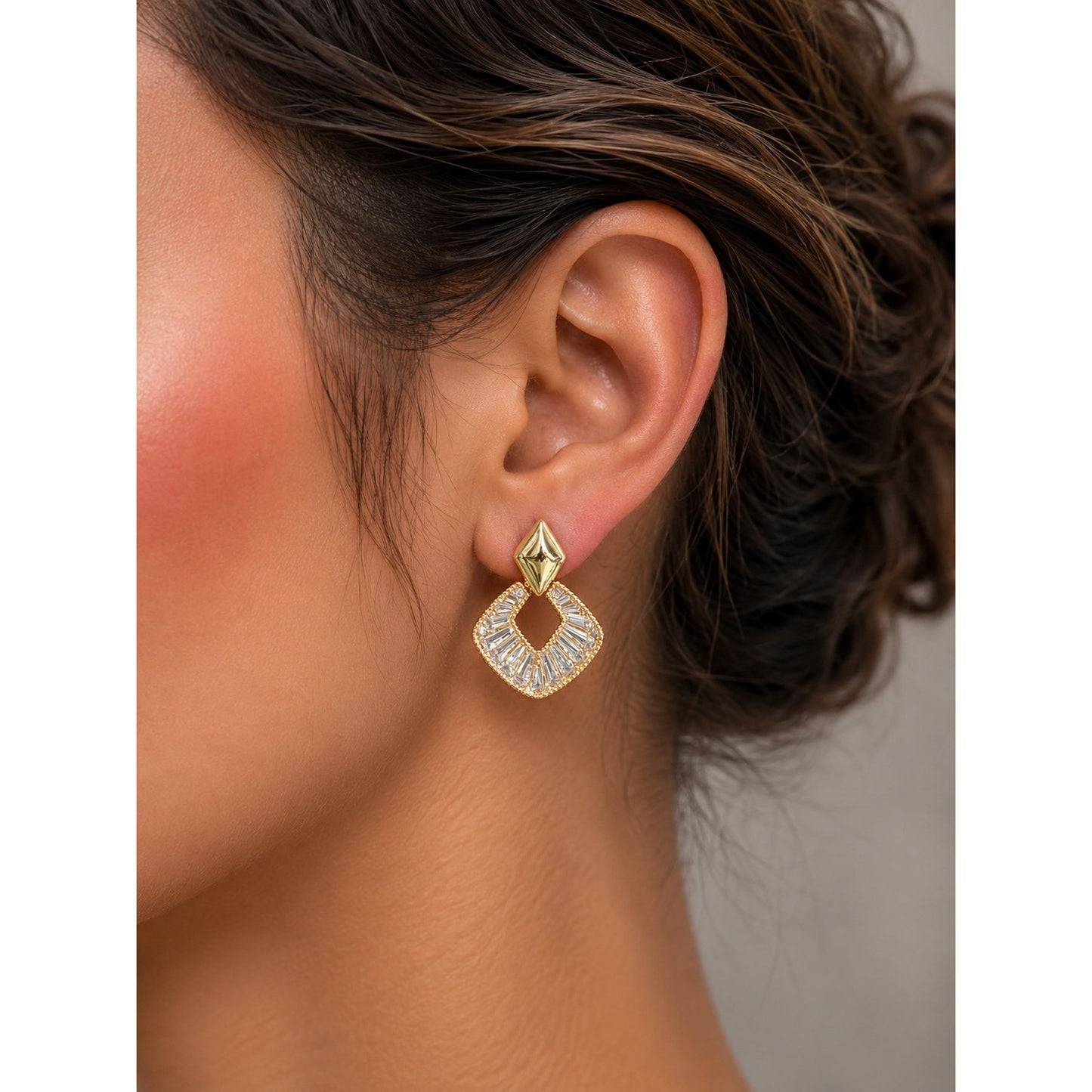 Gold geometric crystal earrings displayed in a premium charcoal velvet jewelry box with luxury studio lighting.