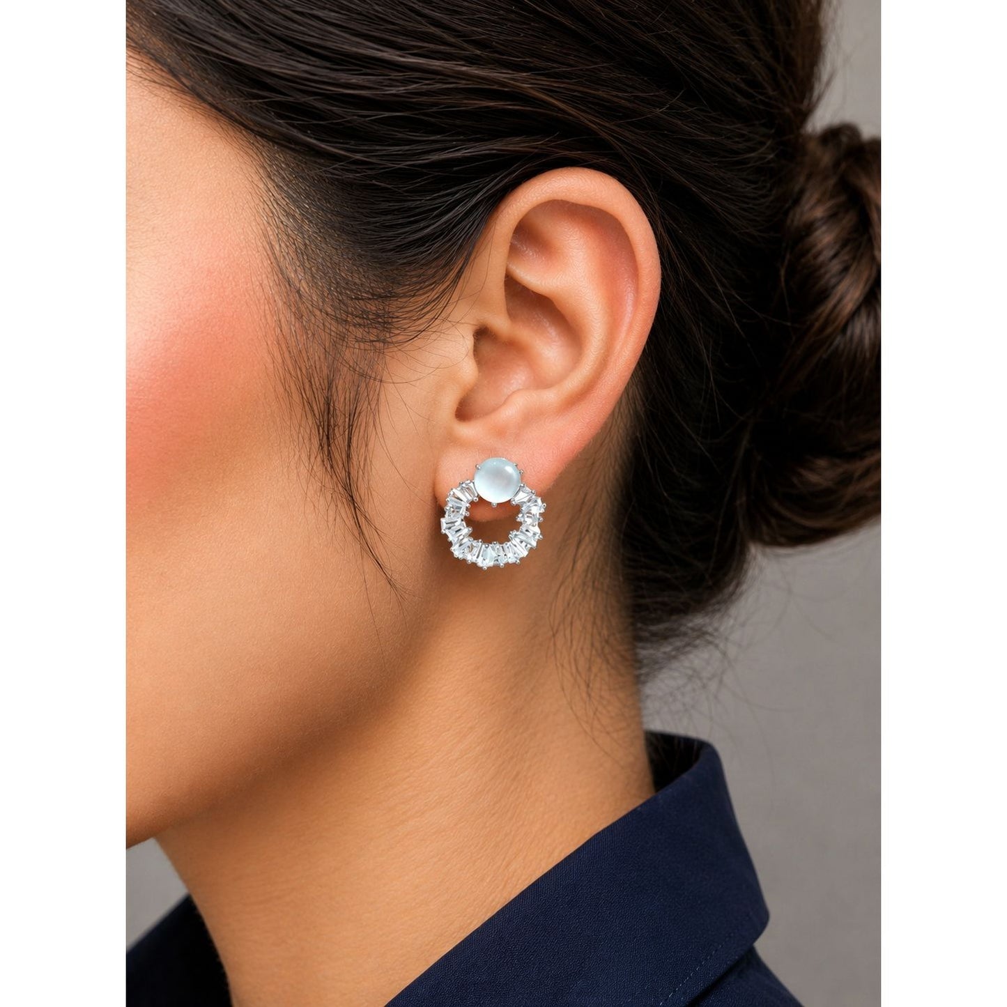 Model wearing moonstone halo crystal stud earrings featuring a luminous center stone surrounded by sparkling baguette-cut crystals.