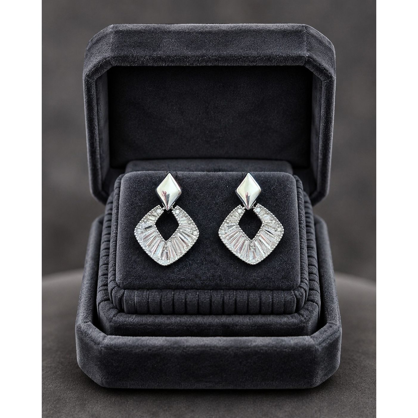 Silver geometric crystal earrings displayed in a premium charcoal velvet jewelry box with elegant studio presentation.