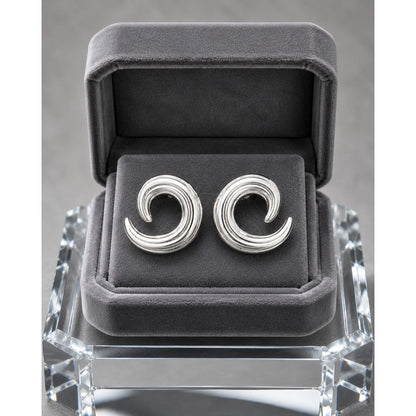 Silver spiral stud earrings displayed in a premium charcoal velvet jewelry box with contemporary sculptural swirl detailing.