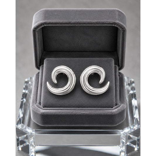 Silver spiral stud earrings displayed in a premium charcoal velvet jewelry box with contemporary sculptural swirl detailing.