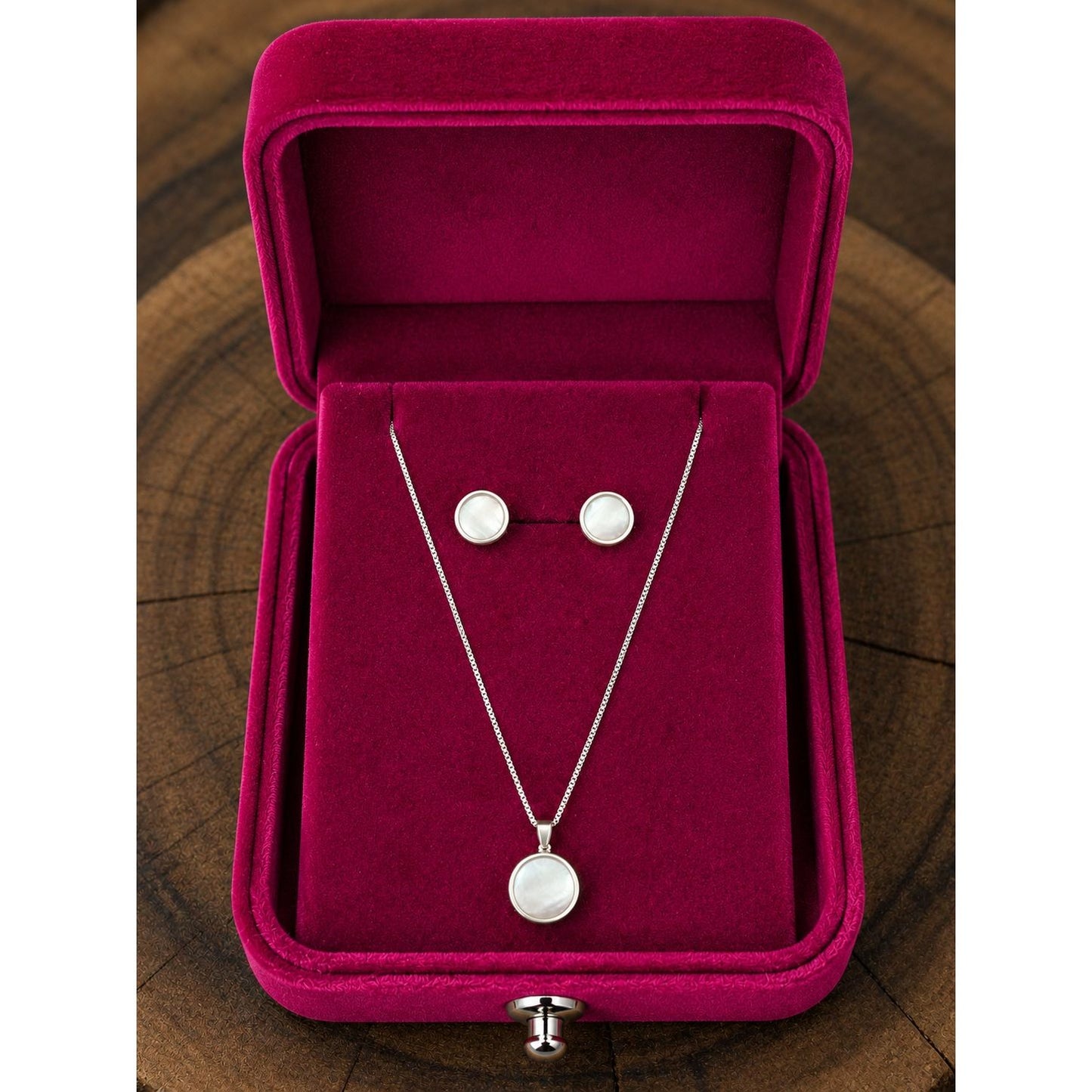 Silver pearl-inspired necklace and stud earring set displayed in a premium fuchsia velvet jewelry box with a sleek contemporary finish.