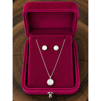 Silver pearl-inspired necklace and stud earring set displayed in a premium fuchsia velvet jewelry box with a sleek contemporary finish.