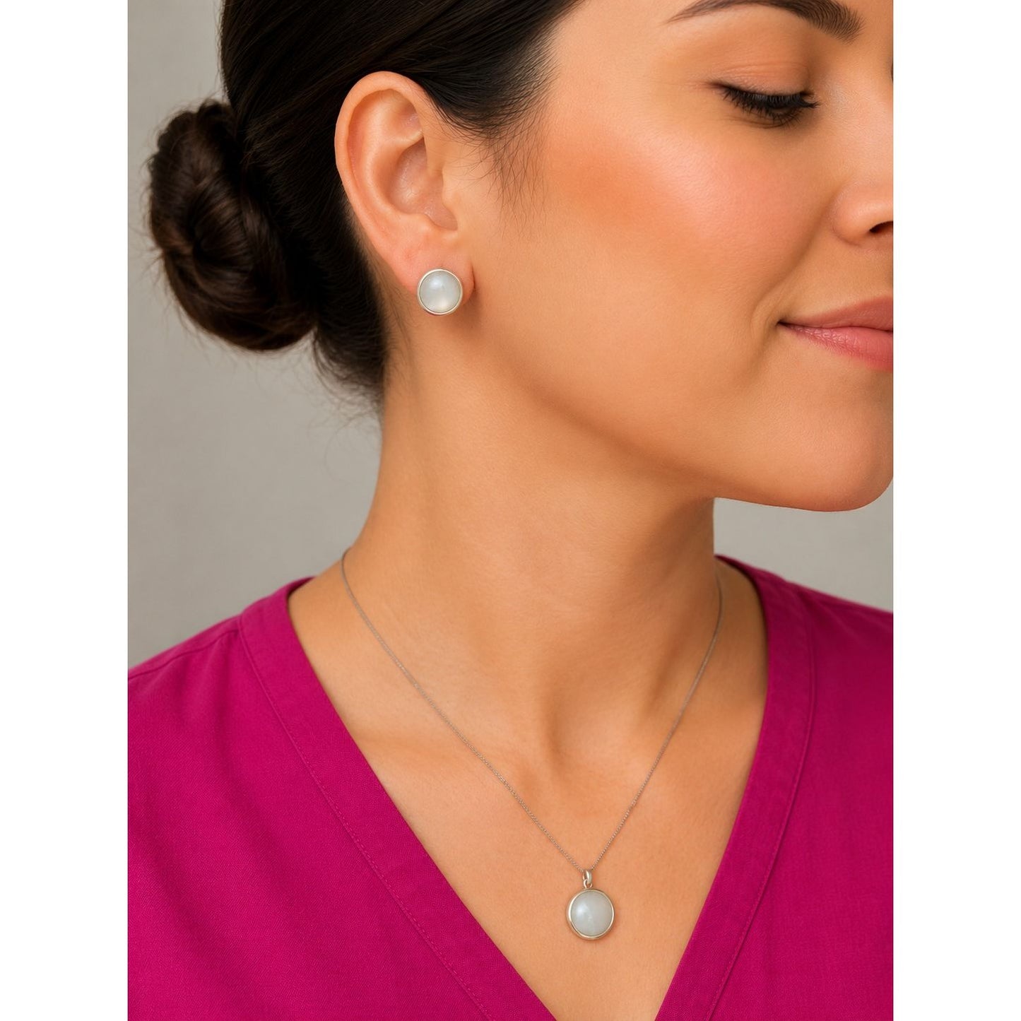 Model wearing a silver pearl-inspired pendant necklace and matching round stud earrings with a minimalist modern design.