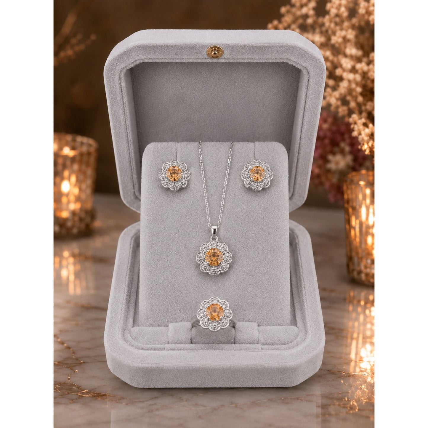 Champagne gold floral halo jewelry set displayed in a premium ivory velvet jewelry box featuring matching pendant, stud earrings, and ring.
