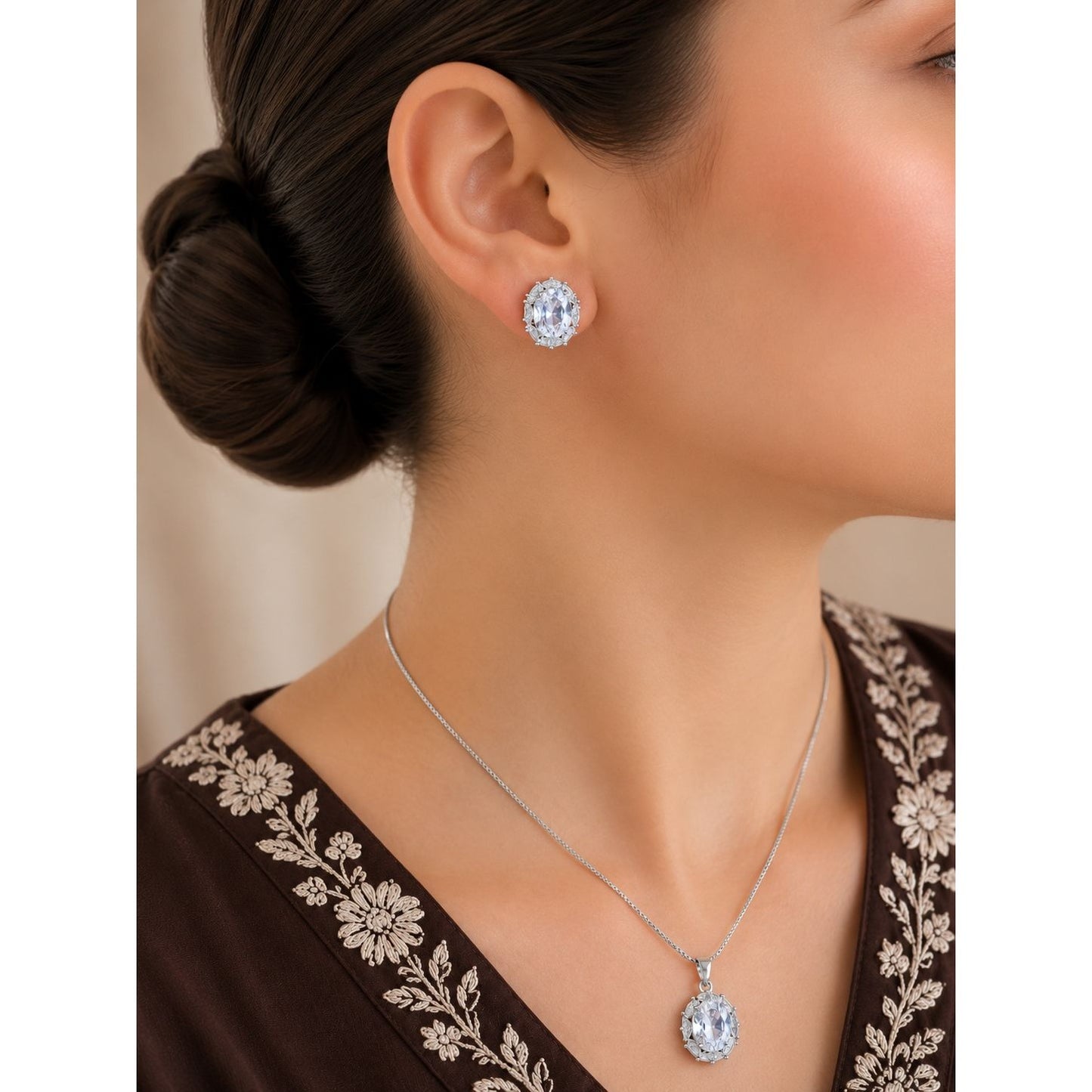 Model wearing a silver oval crystal pendant necklace and matching vintage-inspired stud earrings with sparkling halo accents.